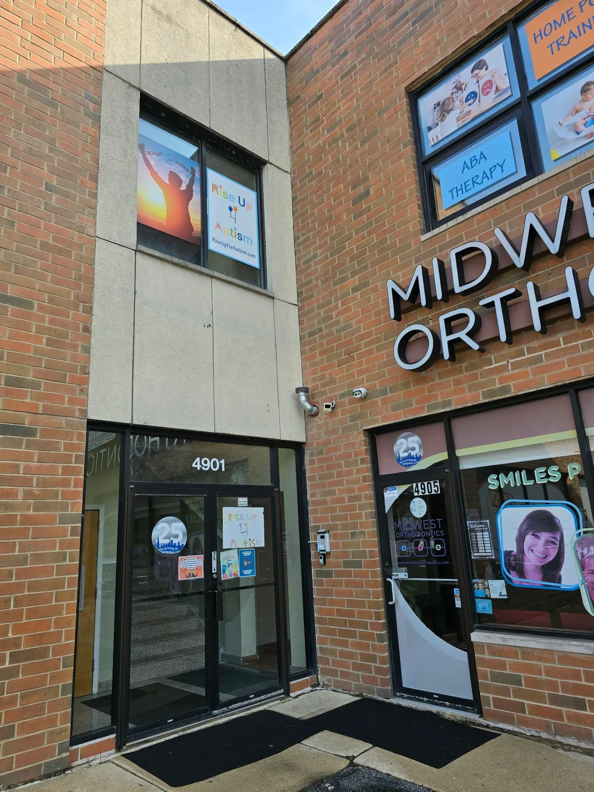 The Rise Up For Autism entrance at 4901 N Kedzie Ave in Chicago, with the center's sign in the door and in the upstairs window.