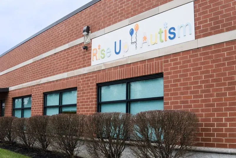 The Rise Up For Autism Tinley Park center, a brick building with the branded sign mounted above the windows.
