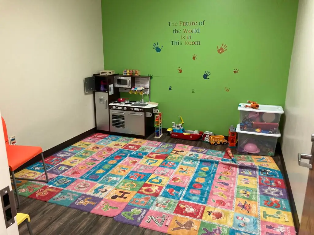 a child's playroom with a play kitchen and play area.