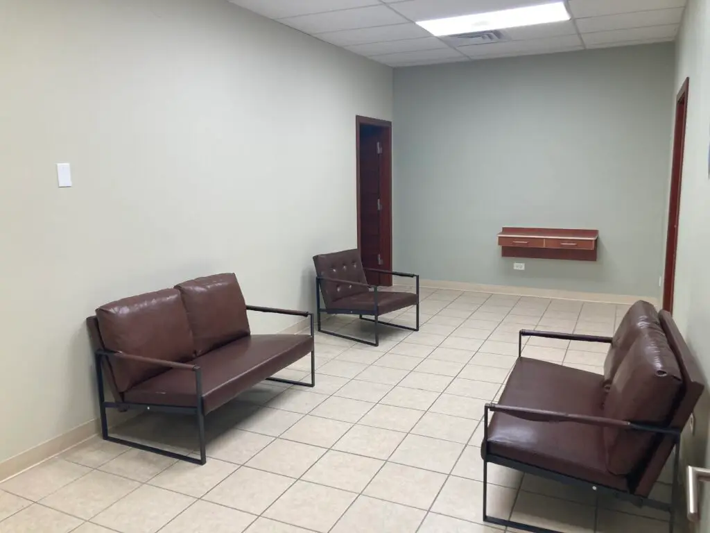 a-waiting-room-with-three-brown-leather-chairs