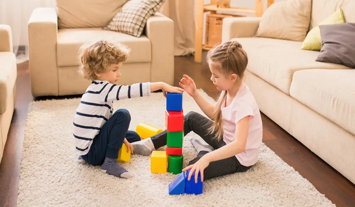 Two kids are playing with building blocks.