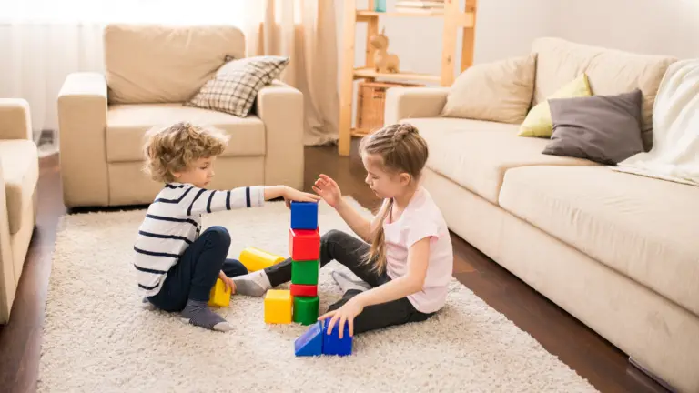 sibling support: a boy and a girl playing blocks in the living room