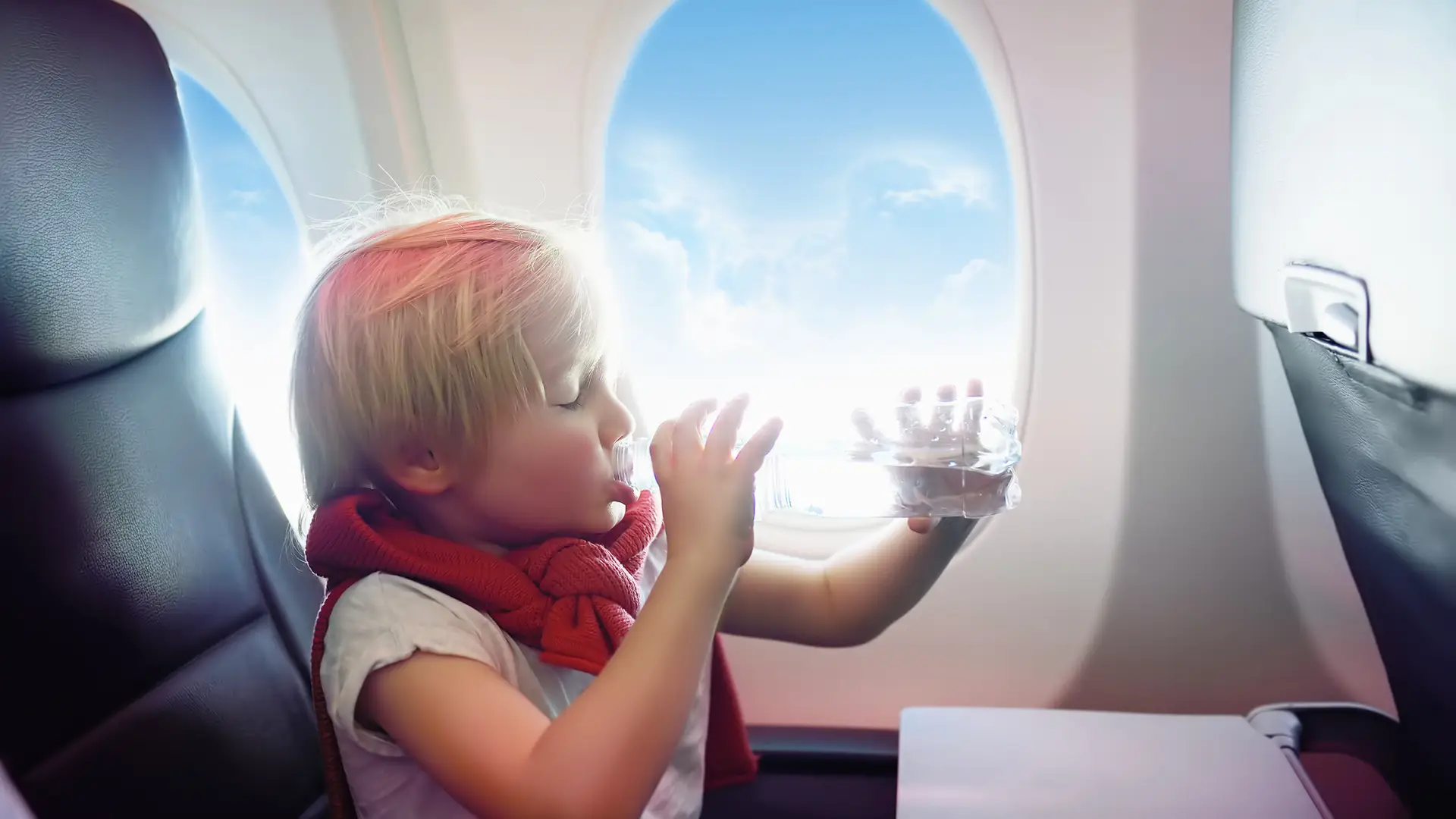 Child drinking water in aeroplane | Sensory-Friendly Travel Tips